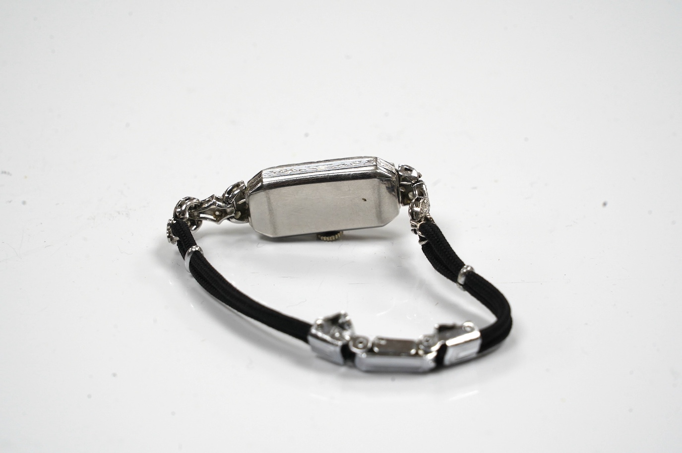 A lady's mid 20th century Buren white metal (stamped platinum) and diamond cluster set manual wind cocktail watch, on a twin fabric strap, gross weight 15.3 grams. Condition - poor to fair